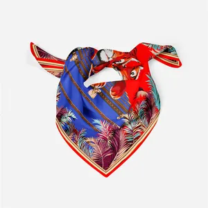 Dettaglio di un foulard di seta quadrato con stampa tigre, piume e bauli di lusso vintage