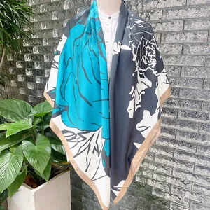 Detail view of large floral silk scarf draped on a mannequin with hand-painted rose patterns