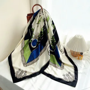 Elegant 130cm floral scarf with blue roses and tassel print draped on a leather handbag