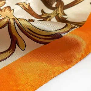 Macro-opname van satijnen zijden sjaal met barokpatronen en oranje gerolde randen