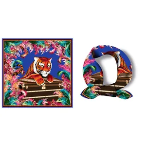 Sciarpa quadrata in seta con tigre, piume floreali e baule vintage su fondo blu