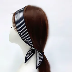 Classic navy blue striped skinny scarf tied as a headband on brunette hair accessory