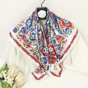 Detail of bohemian paisley silk scarf hanging on a hanger with elegant floral pattern