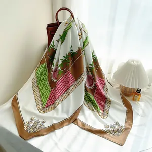Detailed close-up of a floral silk scarf with vintage geometric patterns and tassels