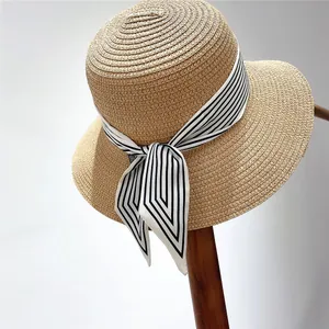 Detailed texture of woven straw sun hat with stylish black and white striped ribbon bow