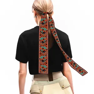 Eleganter ziegelroter Seidenschal mit Paisleymuster als Haarband für Damen getragen
