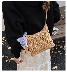 Detail of hand-woven shoulder bag with white lace bow and pearl tassel decoration
