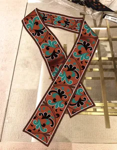 Detail eines Twilly-Seidenschals mit Paisley-Muster und eleganten weißen Kontrasträndern