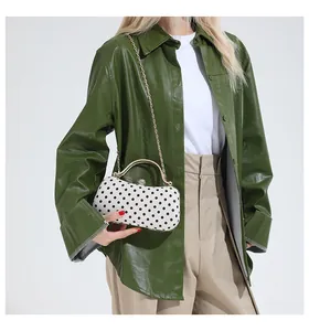 Detailed view of polka dot clutch bag with gold handle and crystal sphere lock
