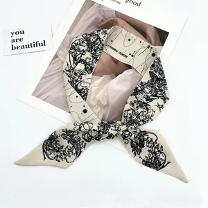 Macro view of cream silk twilly scarf with vintage tarot hand-drawn black prints and stars
