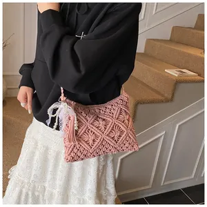 Detail of pink hand-woven bohemian beach bag with fringe tassel and pearl bow decor
