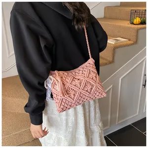 Detailed macro view of pink knit shoulder bag with fringe and pearl lace accents