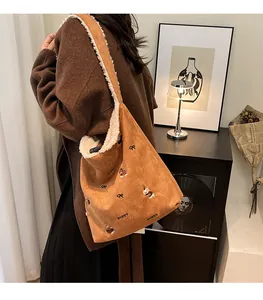 Detail of suede tote bag featuring puppy embroidery and plush faux fur trim on model