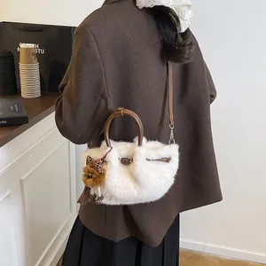 Chique witte handtas van imitatiebont met lederen handvaten en pluche pop-hanger