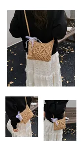 Detail of hand-woven straw crossbody bag with lace bow, pearls and tassel accents