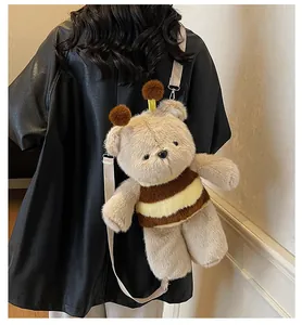 Detail of cute beige plush bear crossbody bag with bee stripes and woven strap on model