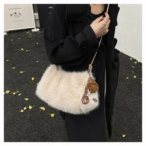 Close-up of plush faux fur shoulder bag with leopard print pom-pom charm on wool coat