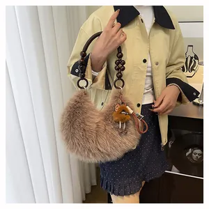 Detailed shot of brown faux fur crescent bag with wooden bead handle and plush charm
