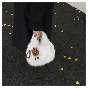 Dettaglio della borsa a secchiello in peluche bianca con ciondolo a mostro e cappello leopardato