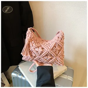 Detailed close-up of pink handmade macramé woven handbag with bohemian tassels