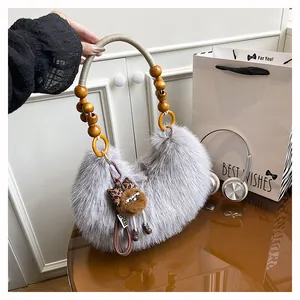 Detail of grey faux fur handbag with beaded wooden handle and cute bear charm