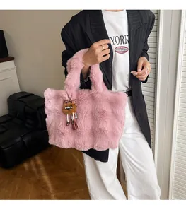 Dettaglio della borsa tote in ecopelliccia rosa con consistenza soffice e orsetto