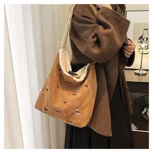 Detail of suede tote bag showing puppy embroidery and soft white shearling lining