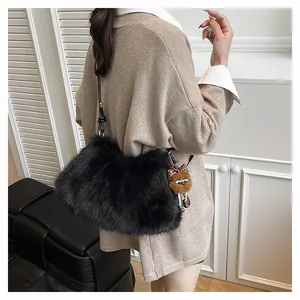 Detail of plush black faux fur shoulder bag with brown cartoon charm and leopard bow