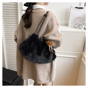 Detail of black faux fur shoulder bag with decorative knotted strap and soft plush texture