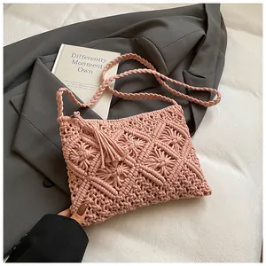 Detailed macro of pink hand-woven texture and fringe tassels on the knit bag
