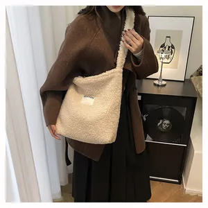 Close-up of beige faux shearling tote bag with SEEYOU embroidery on winter coat