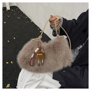 Detail of plush faux fur tote bag in taupe with cute doll pendant and leather handle
