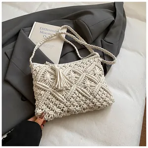 Detail of bohemian cream knit shoulder bag with woven texture and fringe tassels