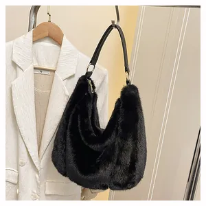 Détail du sac hobo en fausse fourrure noire avec bandoulière en cuir et anneau doré