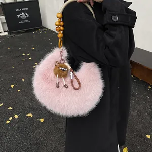 Pink plush crescent hobo bag with braided bead handle and leopard charm on black coat