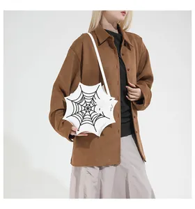 Close-up of a white gothic spider web bag with matching spider charm and embroidery