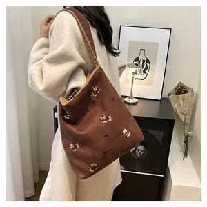 Detail of brown suede tote bag featuring plush lining and puppy embroidery work