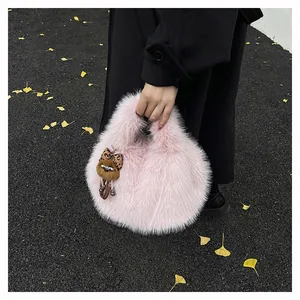 Dettaglio borsa a secchiello in ecopelliccia rosa con ciondolo a forma di orso