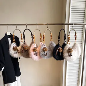 Faux fur crescent handbags with beaded handles in various colors on a rack