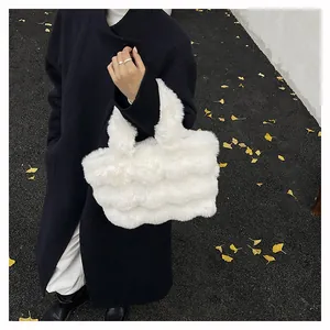 Borsa tote in ecopelliccia bianca con trama soffice abbinata a un cappotto invernale nero
