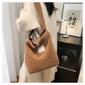 Close-up of brown faux shearling tote bag with SEEYOU patch on beige winter coat