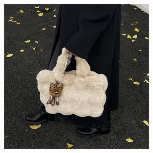 Dettaglio della borsa tote beige in ecopelliccia con ciondolo a orso leopardato