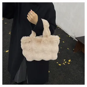 Dettaglio borsa tote in ecopelliccia beige tenuta da una modella con cappotto nero