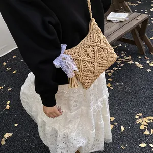 Beige hand-woven crossbody bag with white lace bow on model with autumn leaves