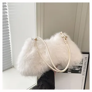 Detail of white plush shoulder bag featuring a knotted faux leather strap and soft texture