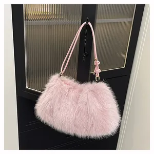 Detailed macro view of pink faux fur shoulder bag with gold metal ring and leather strap