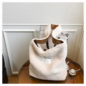 Detail of soft cream faux shearling tote with contrast brown lining and SEEYOU label