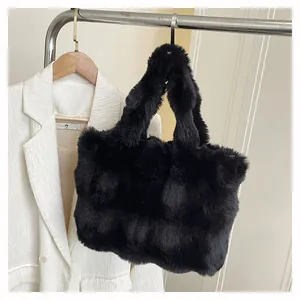 Dettaglio di una borsa tote in ecopelliccia nera con consistenza soffice appesa