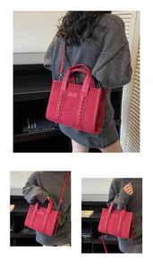 Detailed stitching and embossed Tote logo on a red suede tote bag with detachable strap