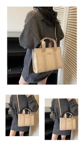 Detail showing beige suede tote bag with TOTE patch and woven decorative side straps